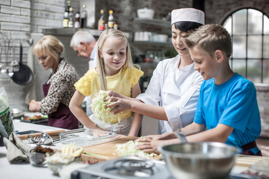 Female chef instructing kids in cooking class