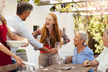 Happy family setting table outside for lunch