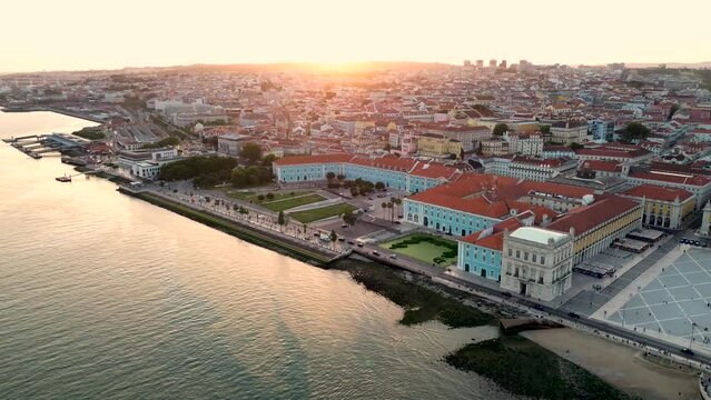 A magnificent aerial view of Tourist center of the old European city, the capital of Portugal - Lisbon and river - Teju, Tagus. Warm sunset light. 4k stock drone video.