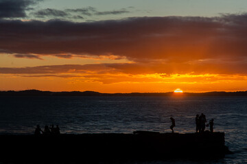 Tourists are seen enjoying the sunset from the pier at Porto da Barra beach in the city of Salvador, Bahia.