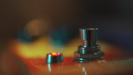 Guitarist pushing on effect pedal footswitch with foot