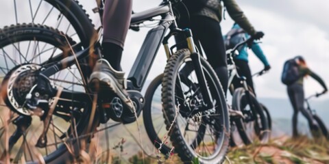 Fototapeta premium Close-up on a group using electric bikes on a mountain trail, eco-friendly transport, overcast weather. 
