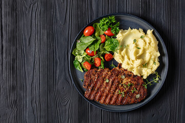 grilled pork steak with mashed potato and salad