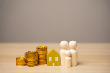 Miniature figures of the family stand near the house and coins. The concept of family budget,...