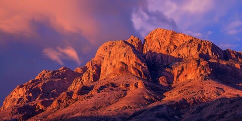 Obraz premium Isolated desert mountain, close-up on vivid sunrise colors reflecting off rocky surface, tranquil dawn. 