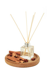 Reed diffuser, anise star and cinnamon isolated on white background.