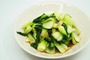 Healthy and delicious menu, stir fried vegetables or Bok Choy with garlic and oyster sauce on white background. Close up the food.