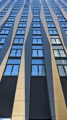 Modern apartment buildings on a sunny day with a blue sky. Facade of a modern apartment building with black windows pattern