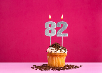 Birthday cupcake with candle number 82 - Birthday card on pink background