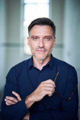 Portrait von einem mittel alten Mann mit Dreitagebart im Dunkelblauen Hemd