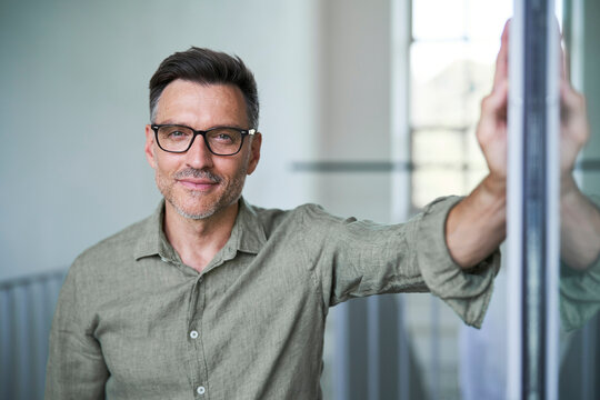 Portrait von einem mittel alten Mann mit Brille und Dreitagebart im wei&szlig;en Hemd
