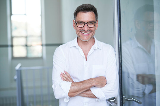 Portrait von einem mittel alten Mann mit Brille und Dreitagebart im wei&szlig;en Hemd