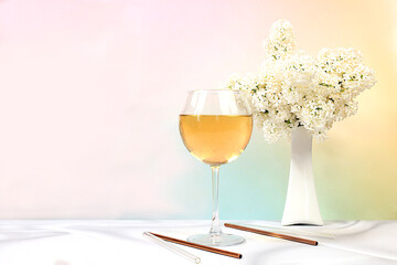 Festive alcoholic cocktail, white wine in a glass on a bright background with a bouquet of white lilacs, summer bar concept, alcoholic drinks at a party, restaurant and cafe advertising, 