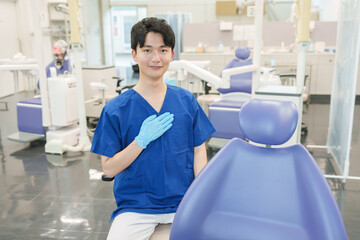 カメラ目線で胸に手を当てる男性歯科医師