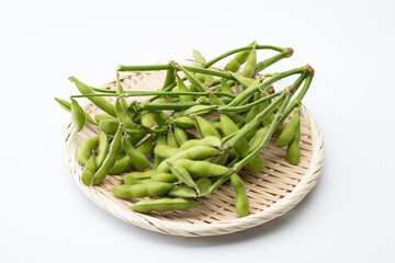 竹ざるにのせた枝付きの枝豆