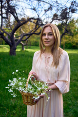 a portrait of a beautiful woman in a peach fuzz dress with a basket of flowers