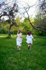 Fototapeta premium a mother and her teenage daughter are hugging and playing in the garden