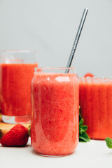 Fruit smoothie in transparent cups. Red strawberry smoothie on a concrete background. The concept of healthy eating. Front view