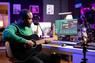 Talented performer teaching how to play acoustic guitar online for a tutorial, hosting internet master class lessons to provide advice for beginners. Artist composer explaining accords on strings.