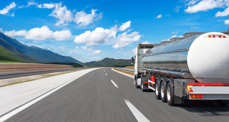 Fuel truck on a picturesque road. A silver tank truck transports fuel.