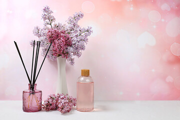 Fragrant rose water, lilac incense sticks and lilac flowers. Spa and wellness composition, salon...