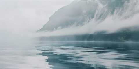 Naklejka premium Fog descending on mountain lake, close-up on water's surface, still and reflective, muted light.