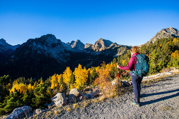 Young hiker woman in autumn in Aiguestortes and Sant Maurici National Park, Spain