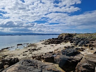 Sandy beach with rocks on Illa de Arousa in the Ria de Avosa, Galicia, Spain