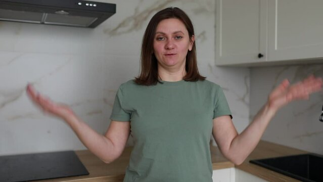 Woman in Green T-Shirt Explains Cooking Techniques in Modern Kitchen