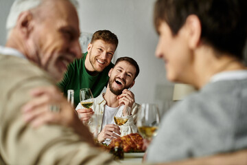 A gay couple enjoys a meal with parents at home.