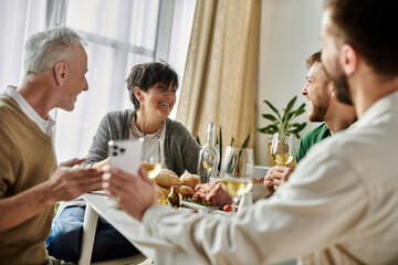 A gay couple enjoys a meal with parents.