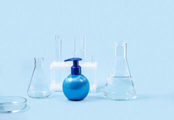 cosmetic bottles and laboratory flasks on a blue background