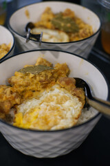 lime leaf rice topped with egg and fried chicken in a bowl. food photo concept