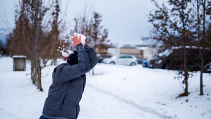 man throwing a snowball in a winter landscape