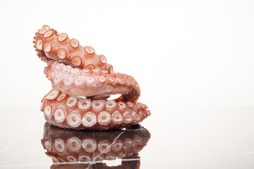 Frozen octopus on a white background on a marble table. Raw iced seafood. Selective focus. Copy space © VLAD ANTONOV
