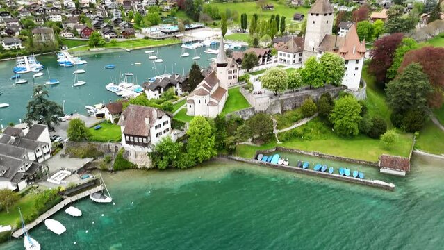 by Spiez Castle ( by Lake Thun (Thunersee), a lake in the Bernese Alps, Spiez Marina , Castle Church in Spiez , Panoramic Train Route (Panorama Express) drone, aerial