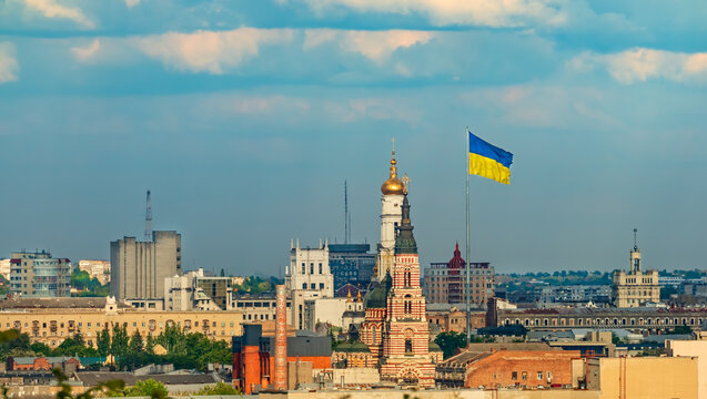 Cityscape of Kharkiv city with buildings, church and Ukrainian flag. Panoramic view of the city center