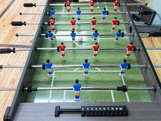 Classic Foosball Table Game With Players in Red and Blue Jerseys During Daytime Indoor Match....