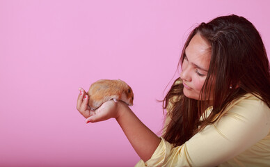 Brunette Girl in the studio holding her hamster