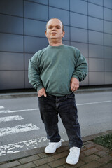 A man with inclusivity stands on a city sidewalk, looking confident and ready to embrace his day.