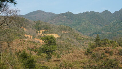 The beautiful mountains landscapes with the green forest and the erupted rock cliff as background in the countryside of the China