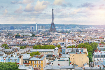 Eiffel Tower in Paris at sunrise. View from above, over the roofs of the city.