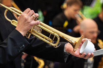 Musiker spielt Trompete mit Tasse als Dämpfer