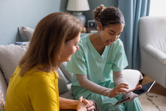 Private healthcare nurse using a digital tablet for a patient health check in their home