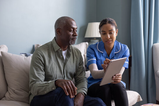 Private healthcare nurse using a digital tablet for a patient health check in their home - Powered by Adobe
