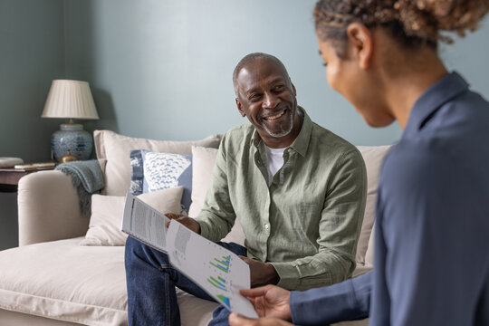Happy senior male meeting with a financial advisor in his home