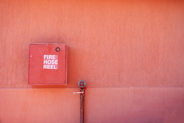 Fire hose reel on the terracotta exterior wall of the house