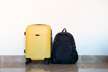yellow suitcase on white wall background in hotel room
