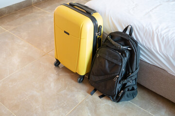 yellow suitcase on white wall background in hotel room