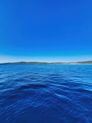 Blue sea and sky. Blurred sea background, closeup. Blue sea surface and clear blue sky. Blue sea blue sky horizon. Beach and tropical sea. An endless blue sea photo. Blue sea water horizon line